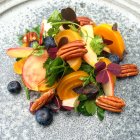 Primo piano di insalata di barbabietola, pecan, mirtillo, mela e prezzemolo su piatto grigio — Foto stock