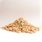 Pilha de cereais com um cereal azul contra fundo branco — Fotografia de Stock