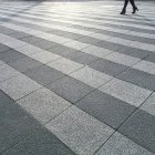 Gambe femminili che camminano in strada con piastrelle — Foto stock