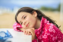 Girl resting head on a table at beach — Stock Photo