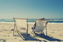 Расслабленный мужчина сидит в шезлонге на пляже — стоковое фото