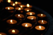 Крупним планом свічки в темряві церкви — стокове фото
