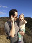 Батько і маленька дочка тримають руки до вух і слухають вітрові удари — стокове фото