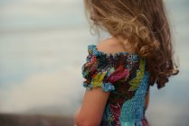 Side view of curly blond girl against blurred nature background — Stock Photo
