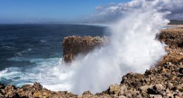 Vue panoramique de la belle vague bleue à côté des rochers — Photo de stock