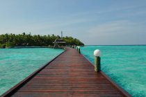 Живописный вид на бирюзовую воду и деревянную пристань, Мальдивы — стоковое фото