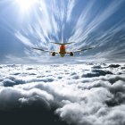 Majestic view of airplane flying above the clouds — Stock Photo