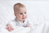 Portrait de bébé garçon mignon couché dans le lit — Photo de stock