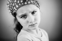 Портрет сварливой маленькой девочки в бандане — стоковое фото