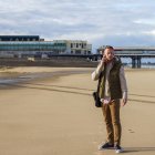 UK, Blackpool, Man with mobile phone standing on beach — Stock Photo