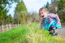 Смеющаяся маленькая девочка, играющая на дорожке — стоковое фото