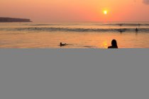 Вид сзади на закат женщины на пляже, Бали, Индонезия — стоковое фото