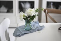 Frasco de flores cortadas na mesa de jantar — Fotografia de Stock