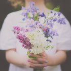 Midsection image of girl holding flowers bouquet — Stock Photo