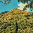Жінка стоїть на природі і дивиться на гору — стокове фото