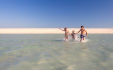 Due ragazzi caucasici e sorella adolescente si divertono in mare — Foto stock