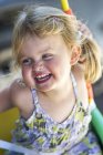 Portrait of blond girl laughing outdoors — Stock Photo