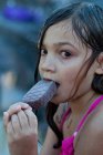Nahaufnahme Porträt eines schönen Mädchens mit nassen Haaren, das Eis isst und in die Kamera schaut — Stockfoto