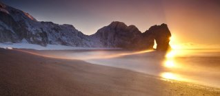 Vista panorâmica de Durdle Door e praia de areia ao nascer do sol, Dorset, Inglaterra, Reino Unido — Fotografia de Stock