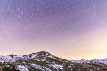 Star trail above snowcapped mountain range, Spain, Catalonia, Gerona, Pyrenees — Stock Photo