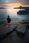 France, Corse, Femme observant le coucher du soleil sur la plage — Photo de stock