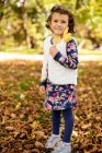 Porträt eines Mädchens, das den Herbst genießt und im Park mit Blättern spielt — Stockfoto