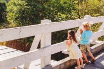 Niño y niña viendo el tren en el puente - foto de stock