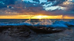 Vista panorâmica da costa ao pôr do sol sob nuvens — Fotografia de Stock