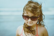 Portrait de fille aux cheveux blonds balayés par le vent portant des lunettes de soleil — Photo de stock