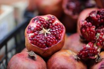 Close-up view of halved and whole ripe fresh pomegranates — Stock Photo