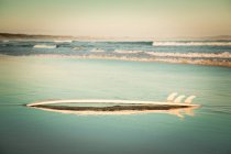 Scenic view of surfboard on empty beach — Stock Photo