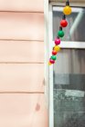 Luzes de fadas multicoloridas contra janela e parede — Fotografia de Stock