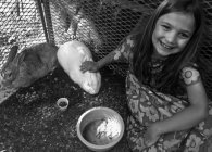 Linda niña sonriente con conejo y conejillo de indias - foto de stock