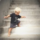 Baby boy going down on stairs — Stock Photo