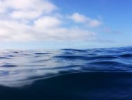 Мальовничий вид на красиву спокійну воду на морі і хмарне небо вище — стокове фото