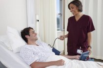 Felice giovane uomo in ambulatorio medico ufficio con medico femminile — Foto stock