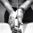Abgeschnittenes Bild eines Mannes, der sich mit Seife die Hände wäscht, monochromes Bild — Stockfoto