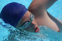 Close-up of swimmer wearing swimming cap and swimming goggles in water — Stock Photo