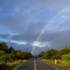 Vista panorámica de Rainbow sobre carretera, Escocia, Reino Unido - foto de stock