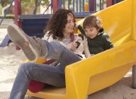 Mutter und Sohn relaxen auf Spielplatz — Stockfoto