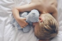 Junge schläft mit Teddybär — Stockfoto