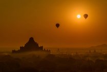 Balões de ar quente voando na manhã nebulosa, Bagan, Myanmar — Fotografia de Stock