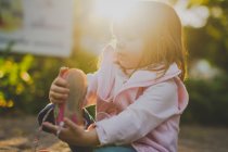 Retrato de niña quitándose el zapato a la luz del sol - foto de stock