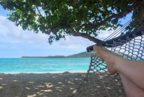 Обрізане зображення людини, що лежить на гамаку на пляжі — стокове фото