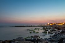 Italia, Sicilia, vista panorámica de la puesta de sol sobre el mar desde las rocas - foto de stock
