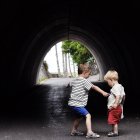 Two little caucasian brothers having fun under arch at vacation — Stock Photo