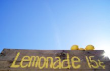 Low angle view of lemonade stand sign under blue sky — Stock Photo