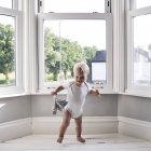 Süßer kleiner Junge tanzt zu Hause mit Stofftier — Stockfoto
