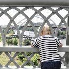 Petit garçon regardant à travers les balustrades sur le pont — Photo de stock