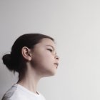 Ritratto di ragazza pensierosa in piedi su sfondo bianco — Foto stock